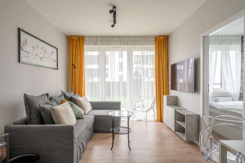 a living room with a couch and a table at RentPlanet - Port Popowice in Wrocław