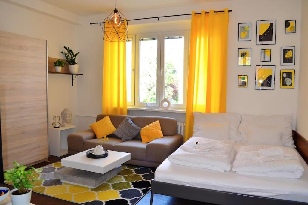 soggiorno con divano e tende gialle di Castle Cozy Apartment a Bratislava
