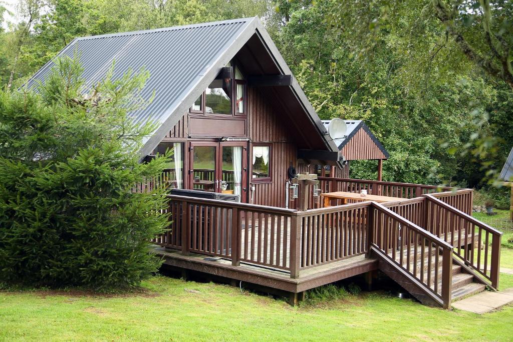 a small cabin with a porch and a deck at Iona Cabin in Taynuilt