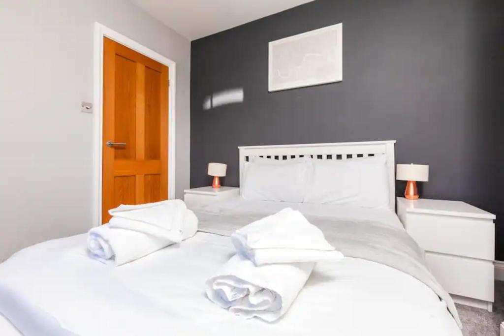 a bedroom with a white bed with towels on it at Modern and Stylish 2 Bedroom House in Brighton in Brighton & Hove