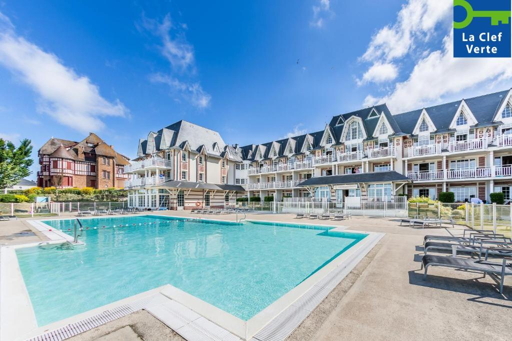 a large swimming pool in a courtyard of a apartment building at Pierre & Vacances Premium Résidence de la Plage in Le Crotoy