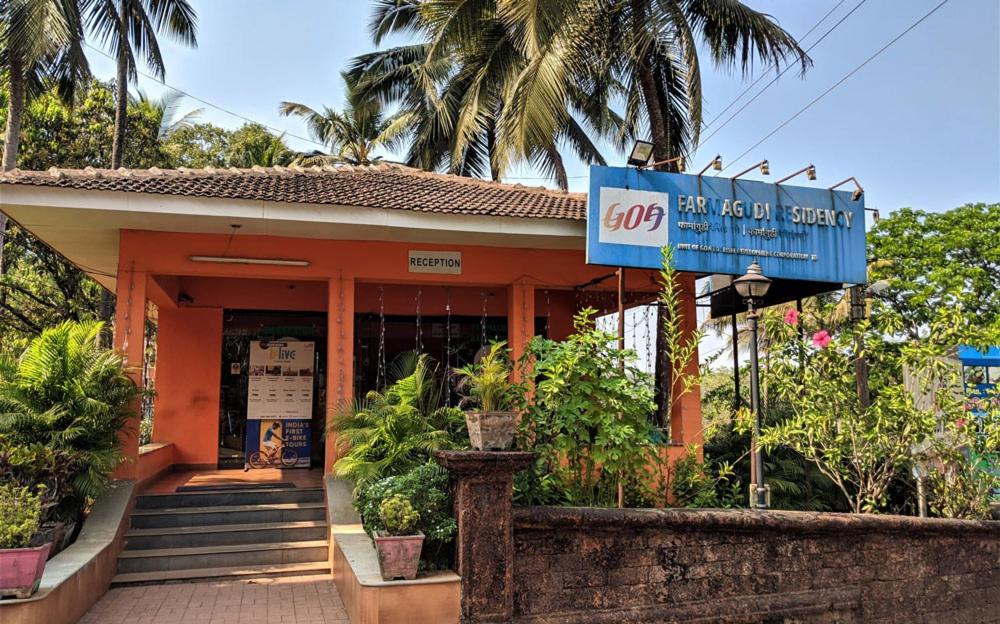 un edificio con una señal azul delante de él en Farmagudi Residency en Ponda