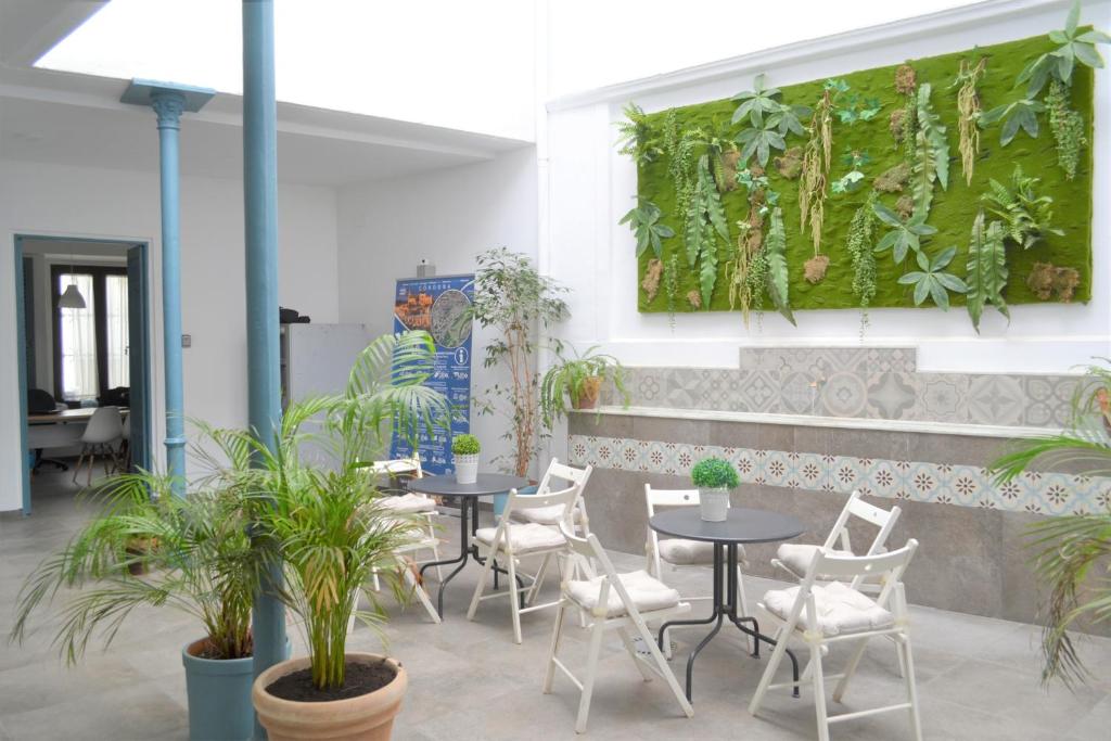 um restaurante com mesas, cadeiras e plantas em SunShine Barroso Centro em Córdoba