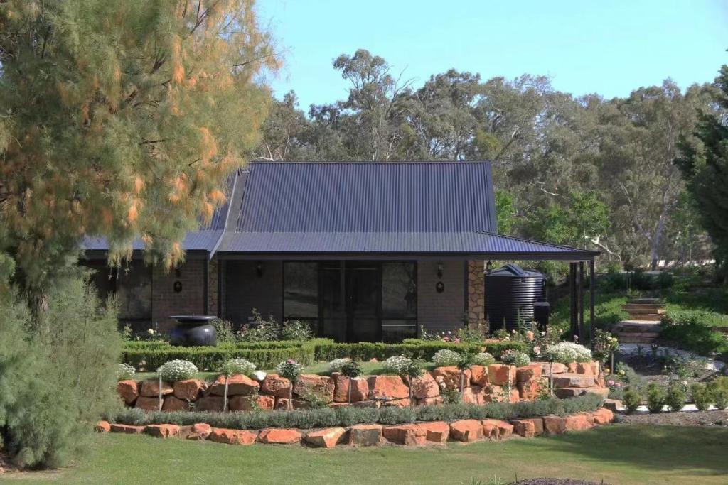 a house with a garden in front of it at Petit Verdot Cottage - A Vineyard Retreat in Barossa Valley in Rowland Flat