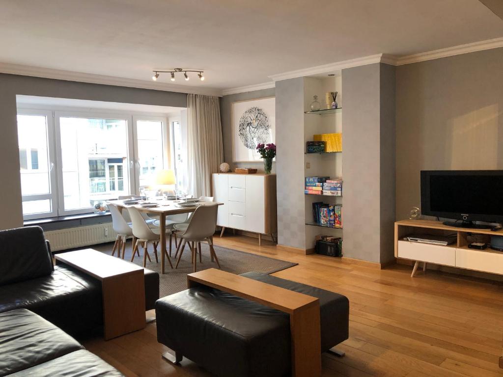 a living room with a table and a dining room at Modern apartment at 2 steps from beach in Ostend