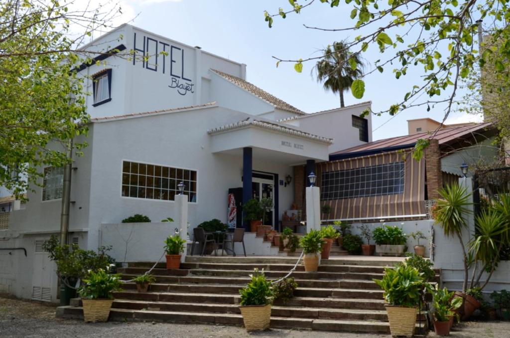 una casa blanca con escaleras y macetas en Hostal Blayet, en Valencia