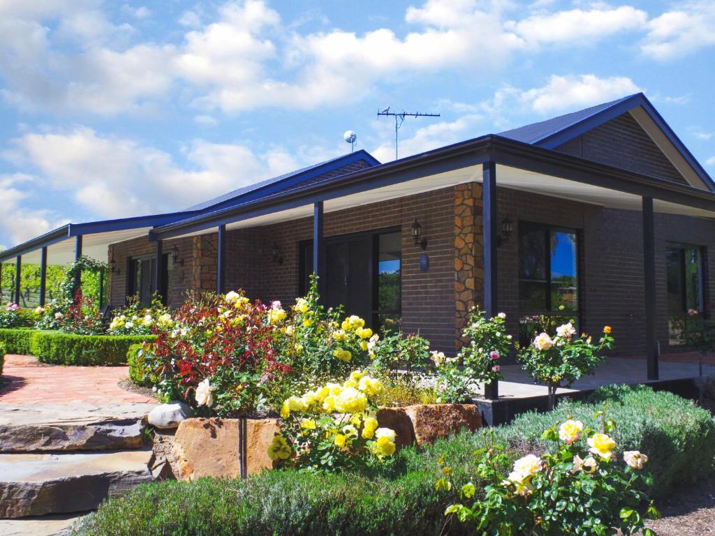 a house with some flowers in front of it at Shiraz Cottage - A Vineyard Retreat in Barossa Valley in Rowland Flat