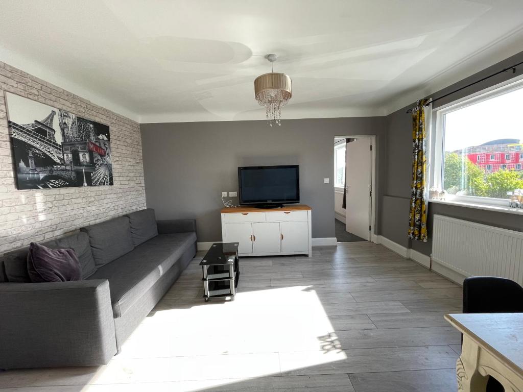 uma sala de estar com um sofá e uma televisão em Lovely 2 bedrooms apartment West derby Liverpool em Deysbrook