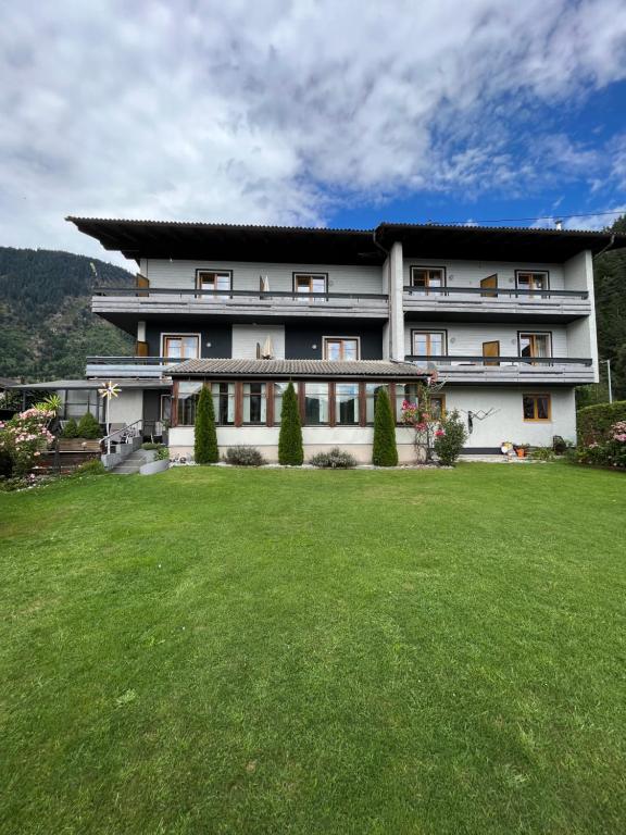 un gran edificio con un gran patio delante en Pension Lärchenhof, en Döbriach