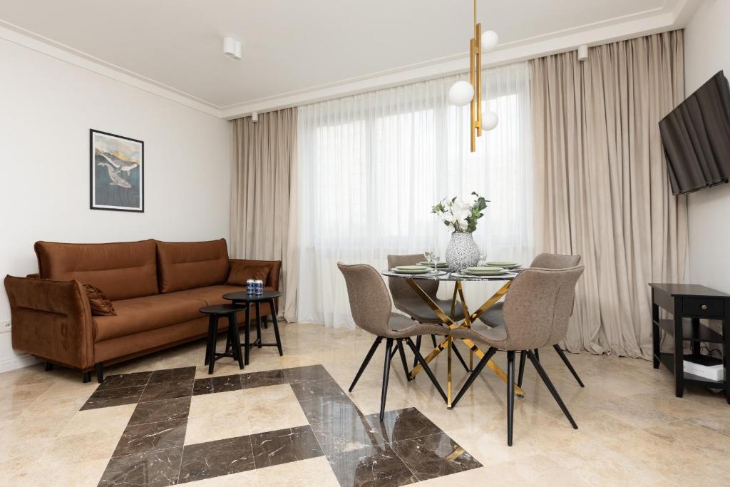 a living room with a couch and a table at Elegant Mokotow Apartment with Parking & AC near Royal Baths Warsaw by Renters Prestige in Warsaw