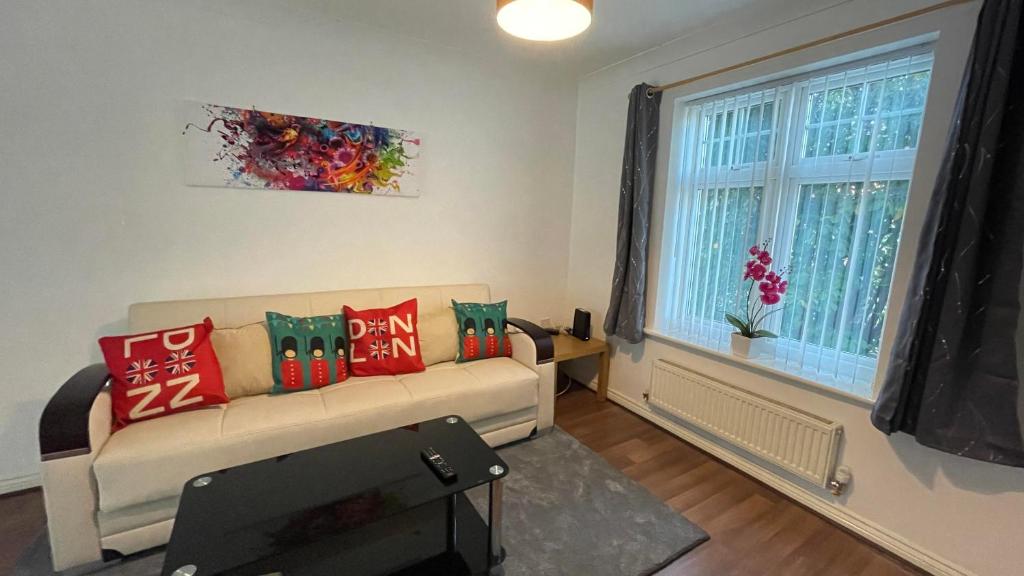 ein Wohnzimmer mit einem Sofa und einem Fenster in der Unterkunft Stylish 4beds house with parking for contractors & families, HS2 NEC in Marston Green