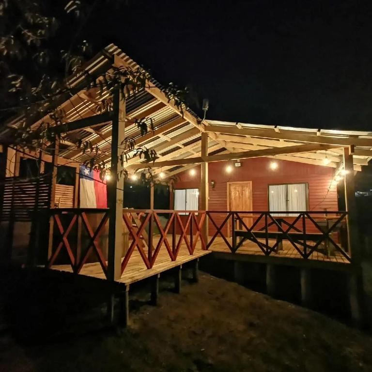 a wooden house with lights on it at night at Cabañas Altos de carewe 2, Lican Ray Chile in Licán Ray