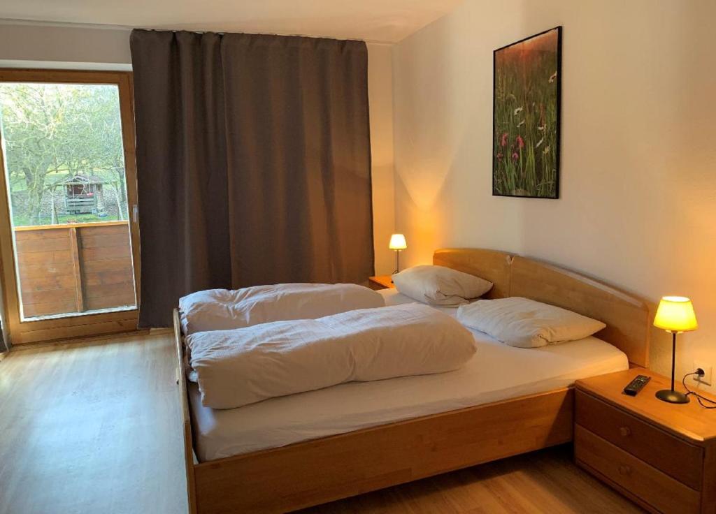 a bedroom with a bed with two pillows and a window at Landgasthof Blasini - Pfahlhof in Zandt