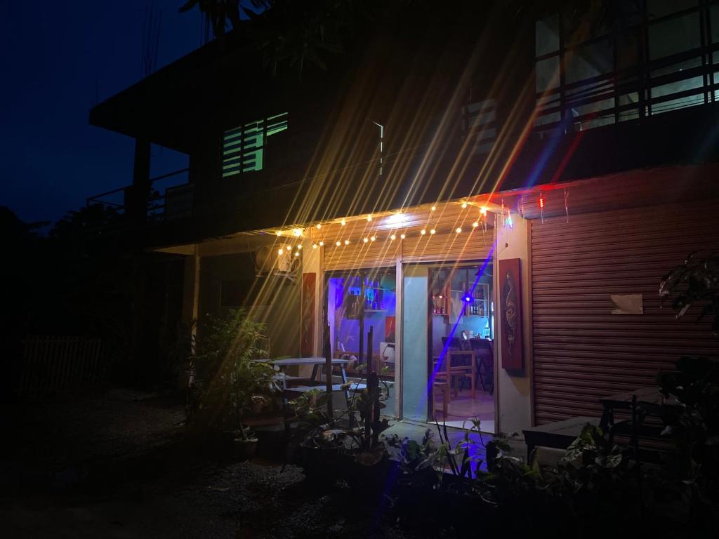 une maison avec des lumières à l'avant de celle-ci la nuit dans l'établissement Jhong Apartment, à Boracay