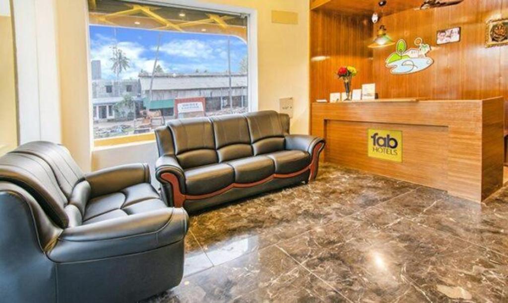 een wachtkamer met leren banken en een salon bij FabHotel Radha Residency in Pondicherry