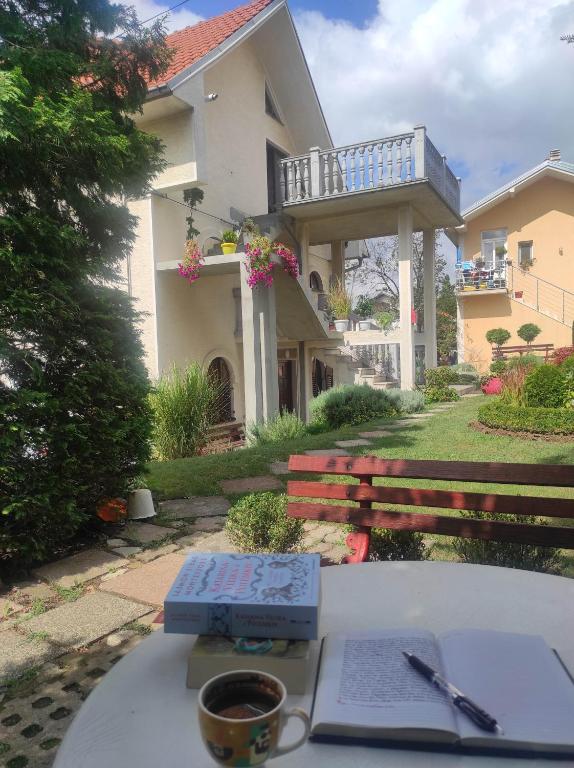 a table with a book and a cup of coffee at Andrea Airport Apartments in Belgrade