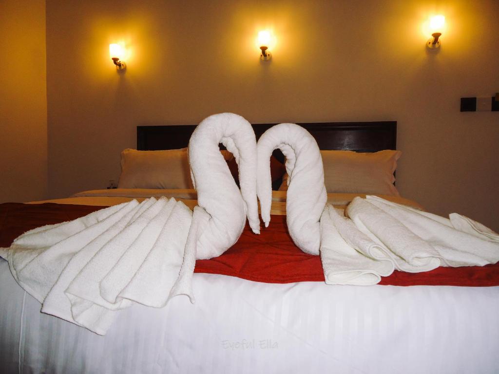 two swans made out of towels on a bed at Eyeful Ella in Ella