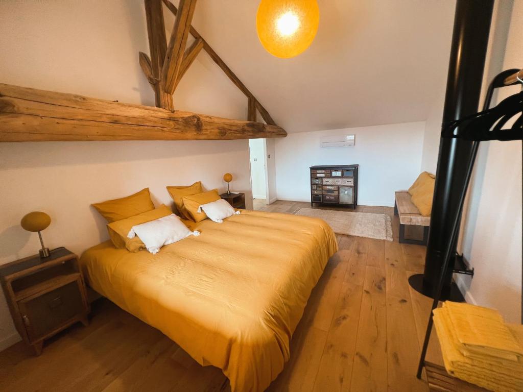 a bedroom with a large bed with yellow sheets at Bulles en Beaujolais in Fleurie