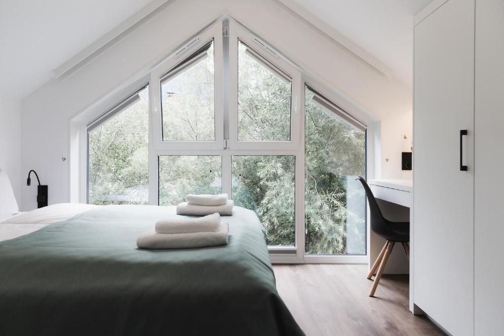 a bedroom with a bed with a large window at Neue stylische HÜSLE by UNIQUE PLACES in Bludenz