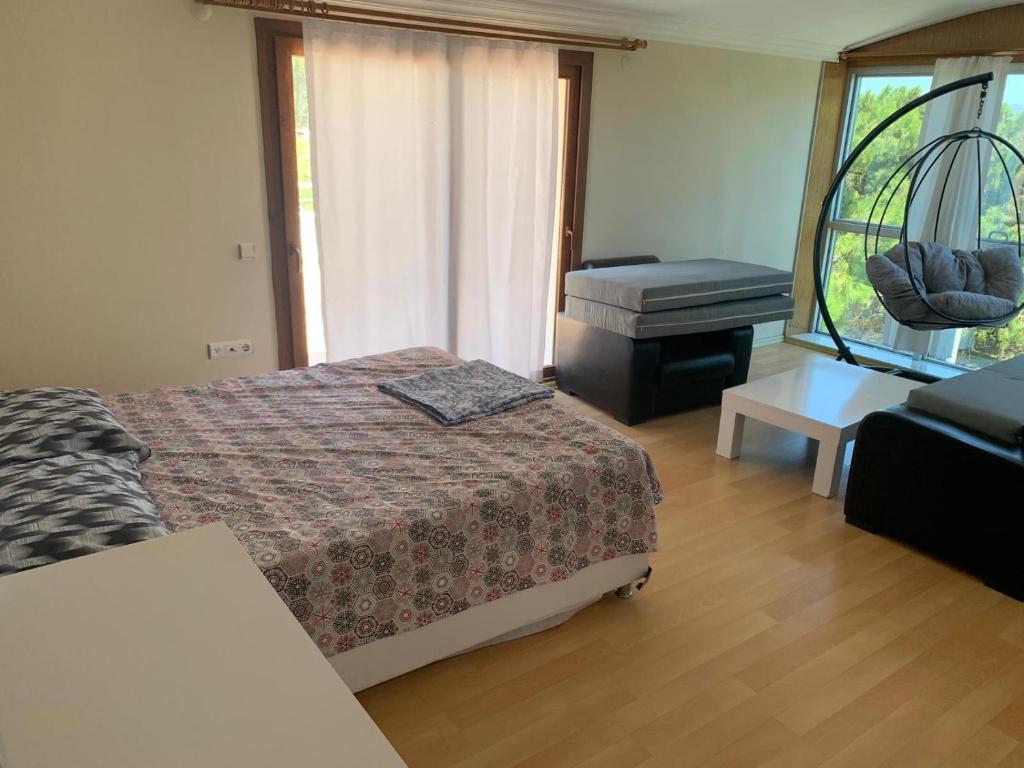 a bedroom with a bed and a couch and a piano at Çamlıkta deniz manzaralı 5+1 dubleks in Didim