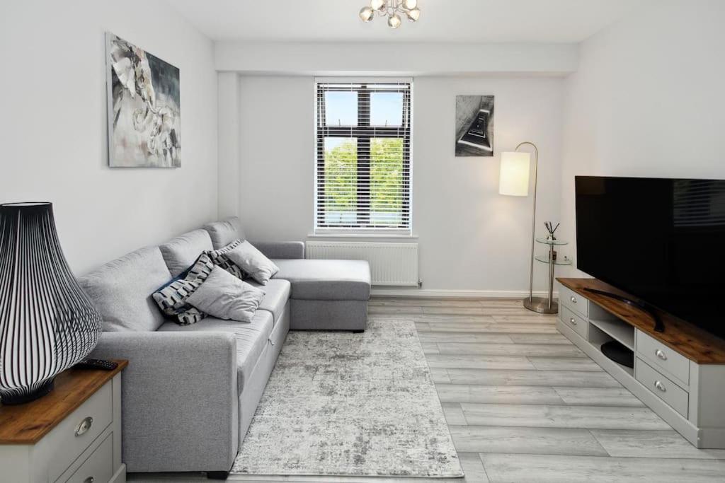 a living room with a couch and a flat screen tv at Modern Watford Urban Luxury Oasis in Leavesden Green