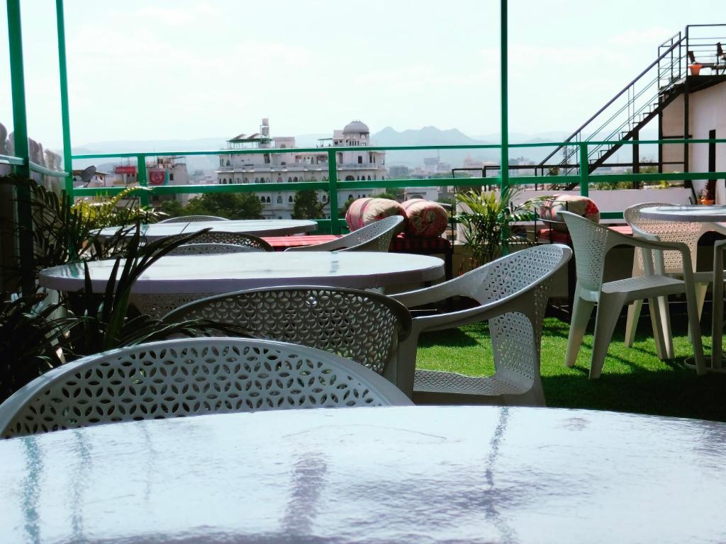 a group of tables and chairs on a balcony at Krishna Stay Guest House in Udaipur