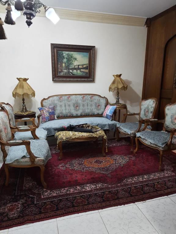 ein Wohnzimmer mit einem Sofa und 2 Stühlen in der Unterkunft Apartment For Rent at Gamal Abdelnasser Street directly near from the sea in Alexandria