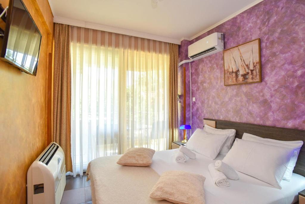 1 dormitorio con cama blanca y pared morada en Apartment Golden Lavender, en Budva