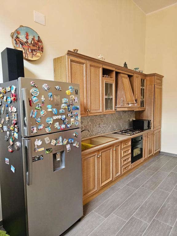 a kitchen with a refrigerator with magnets on it at Acerra's Villa in Nola