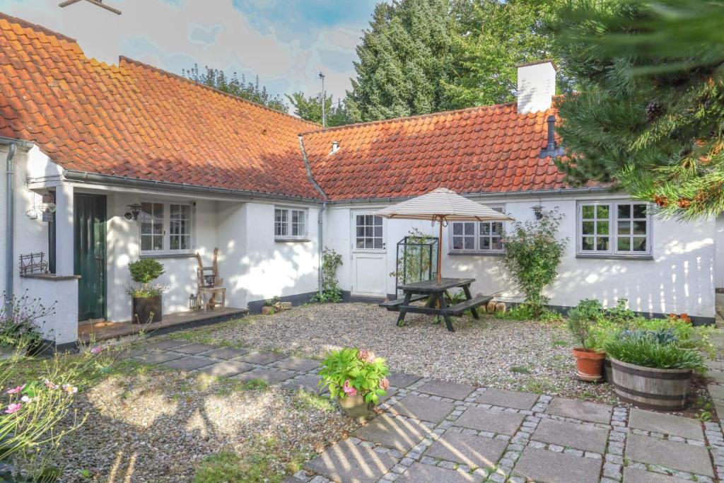 un cottage bianco con tetto arancione di The Guest House a Snekkersten