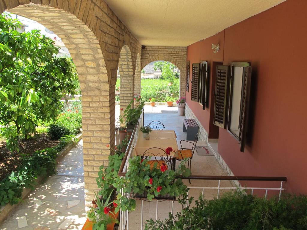 an outdoor patio with tables and chairs in a building at Apartments Aria in Zadar