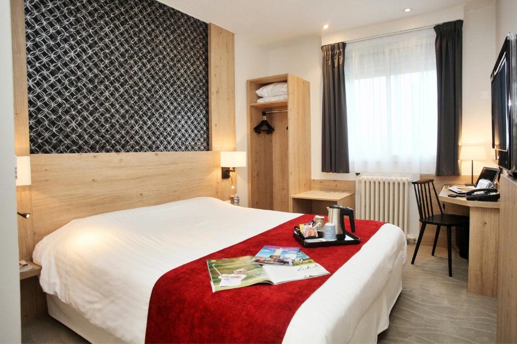 a hotel room with a bed and a desk at Kyriad Vannes Centre Ville in Vannes