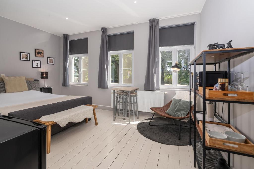 Schlafzimmer mit einem Bett, einem Stuhl und Fenstern in der Unterkunft Spacious Guest Suites near Historic Market - 5 Min Walk in Brügge