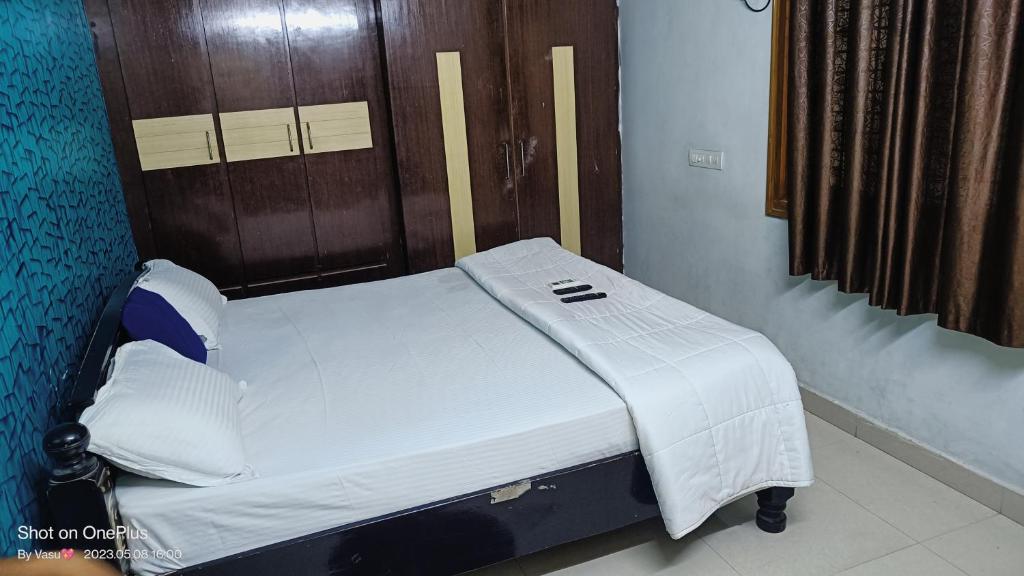 - un lit d'hôpital dans une chambre dotée d'un mur en bois dans l'établissement gratifiedhomestay, à Visakhapatnam