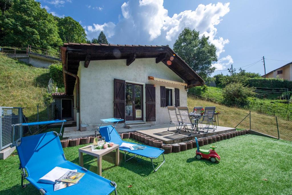 un patio trasero con sillas, una mesa y una casa en Ca' Mia Panoramica - Happy Rentals, en Lugano