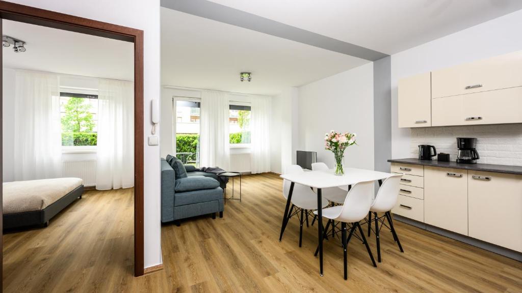 Il comprend une cuisine et un salon avec une table et un canapé. dans l'établissement Native Apartments Poznańska 7, à Cracovie