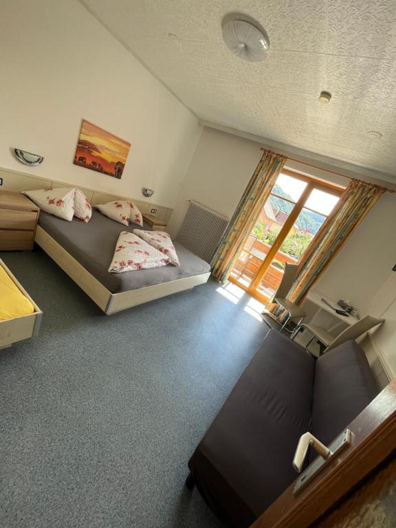 una camera da letto con due letti e una finestra di Pension Lärchenhof a Döbriach