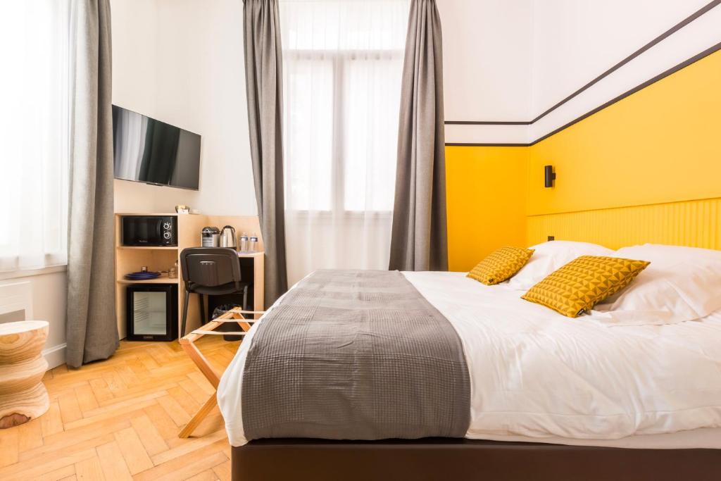 um quarto com uma cama grande e uma parede amarela em Le Chat Qui Dort - Villa Gounod em Lille