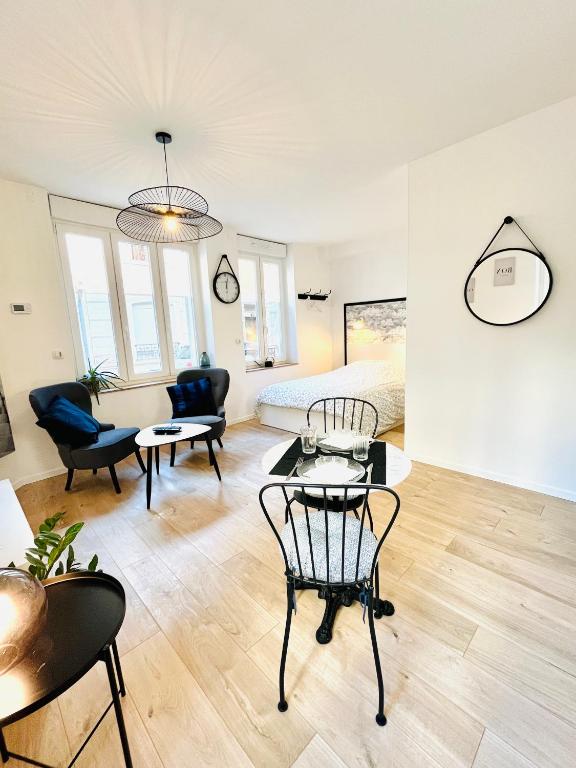 un salon avec un lit, une table et des chaises dans l'établissement BELLE TOUR, à Reims