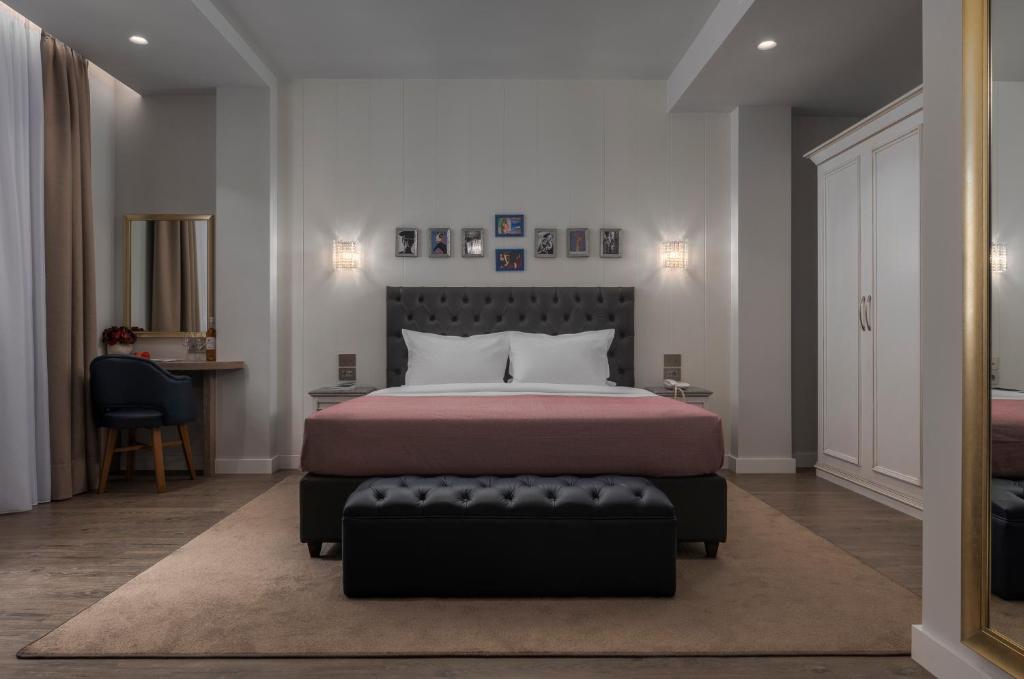 1 dormitorio con cama y banco. en No 39 Svolou Suites, en Tesalónica