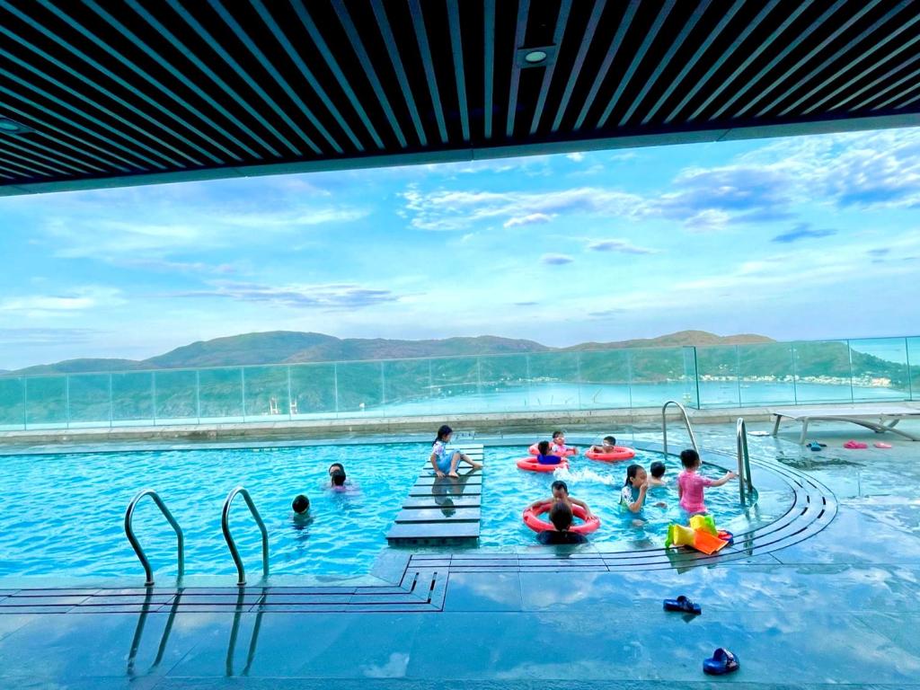 um grupo de pessoas na água em uma piscina em Căn hộ view biển cao cấp Altara em Quy Nhon