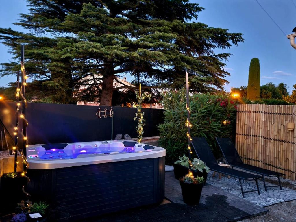 a jacuzzi tub in a backyard at night at La pause en luberon in Cavaillon