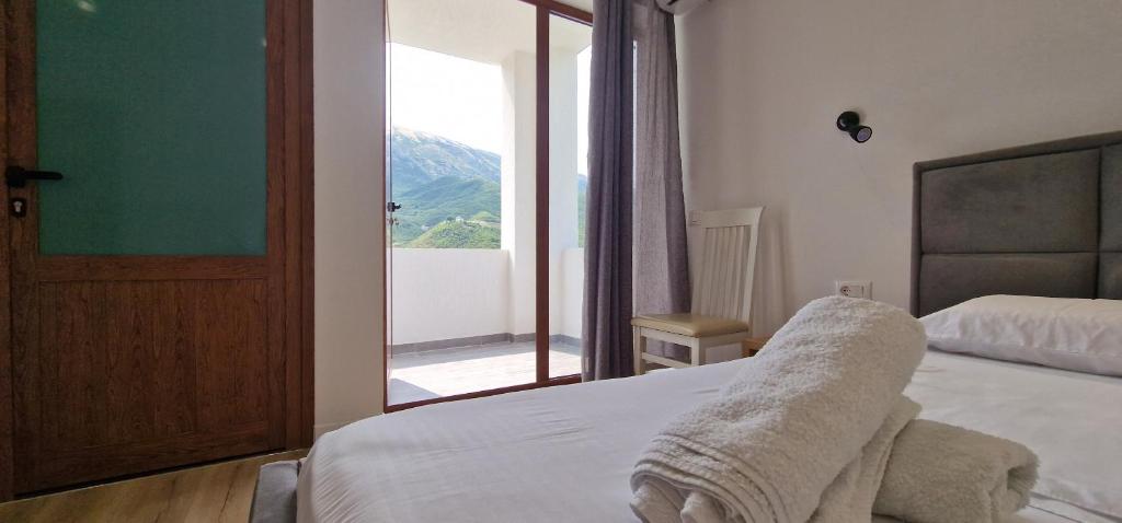 a bedroom with a bed and a window with a view at Kutal Parkinn Hotel in Përmet
