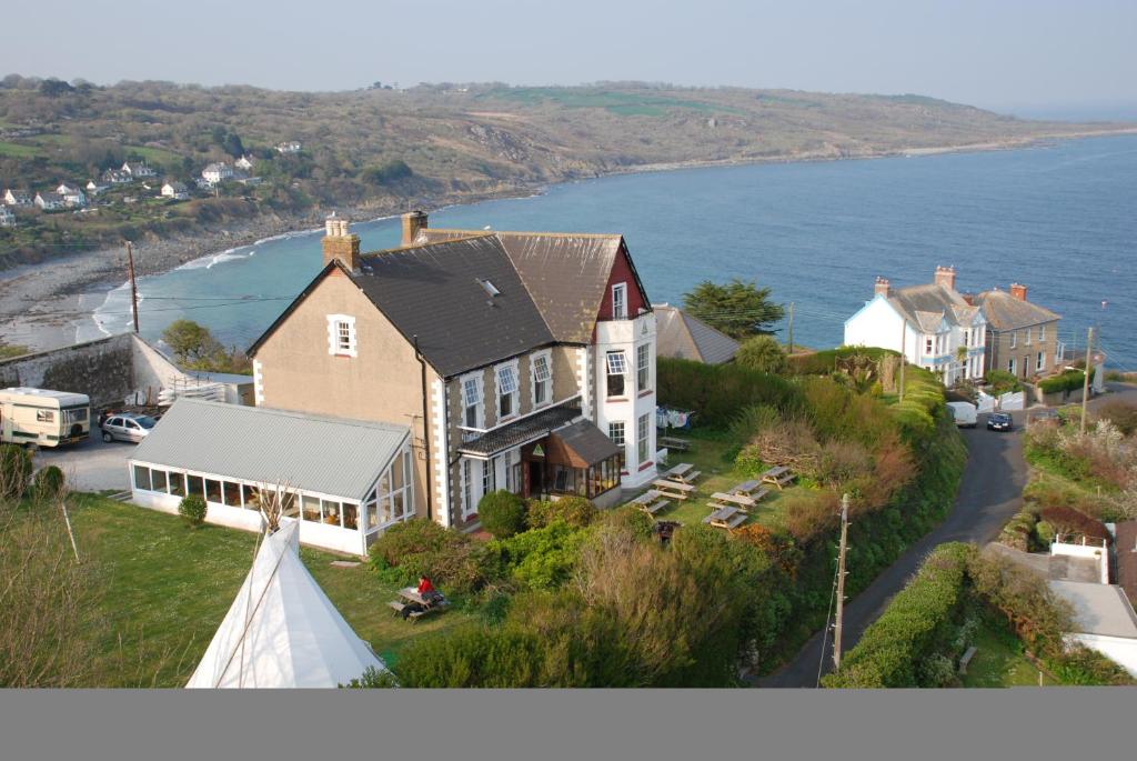 an overhead view of a large house with a view of the ocean at YHA Coverack in Coverack