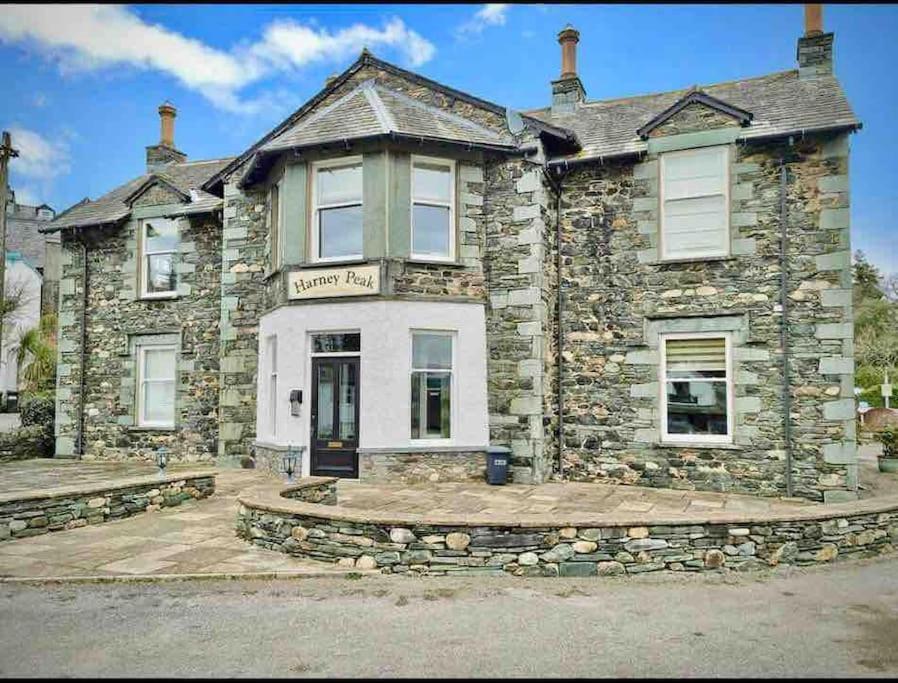 a stone house with a sign on the front of it at A charming luxury apartment! in Portinscale