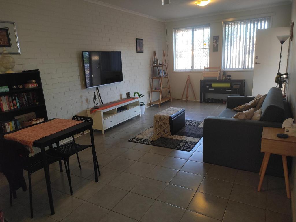 uma sala de estar com um sofá e uma mesa em South Hedland Accomodation - Nice - Tidy - Secure em South Hedland
