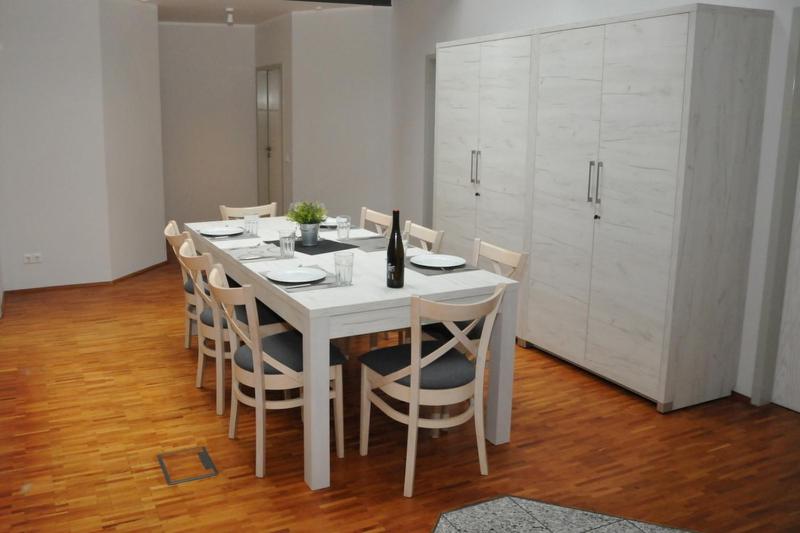 a white dining room table with chairs and a white cabinet at Rooftop Regensburg in Regensburg