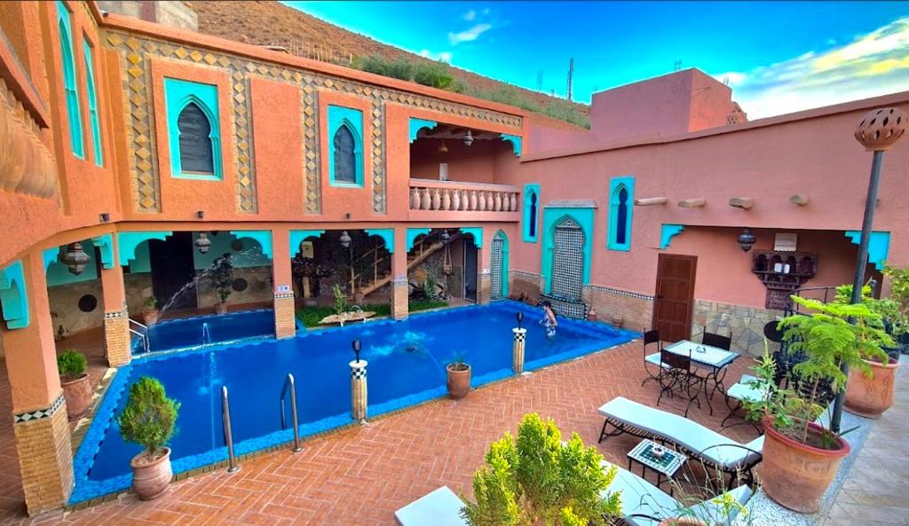 a large building with a swimming pool in a courtyard at Dar Ahlam Dades in Aït Ouaddar