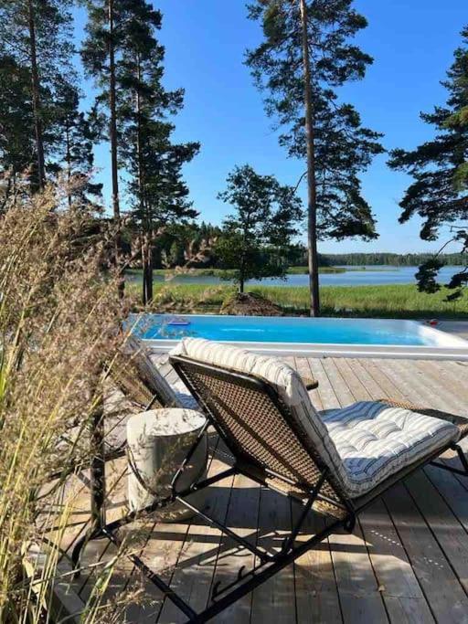 a chair sitting on a deck next to a swimming pool at Beautiful Villa by the sea in Porvoo