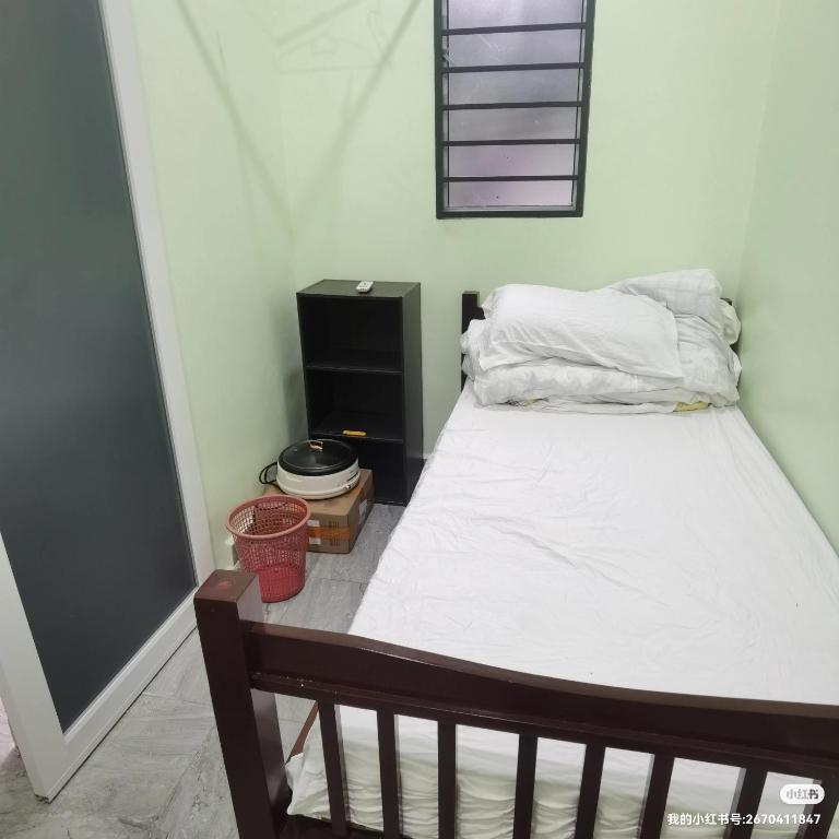 ein kleines Schlafzimmer mit einem Bett und einem schwarzen Schrank in der Unterkunft 2号房有厕所厨房冰箱洗衣机 in Kuala Lumpur